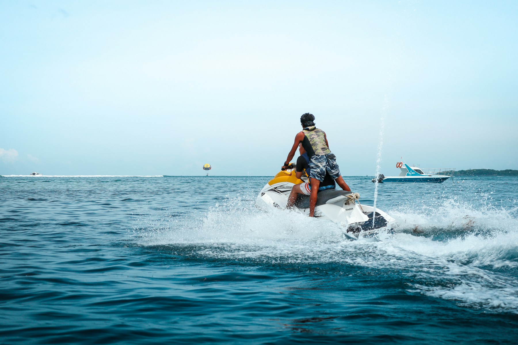Riders enjoying a personal watercraft on the sea